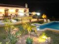 view to garden, pool and terrace at night